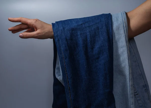 Vrouwelijke hand bedrijf jeans — Stockfoto