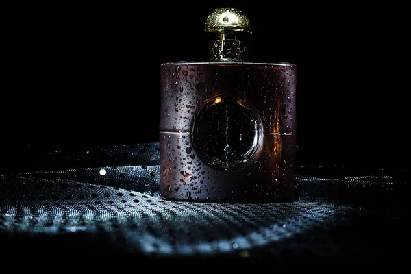 Flasche Parfüm vor dunklem Hintergrund — Stockfoto
