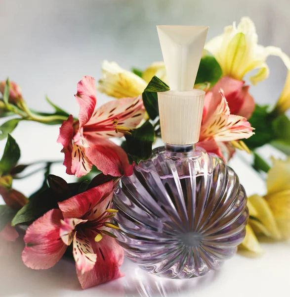 Parfum spray fles met roze bloemen — Stockfoto