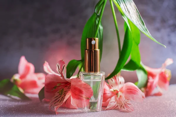 Kvinnlig parfym med rosa blommor — Stockfoto