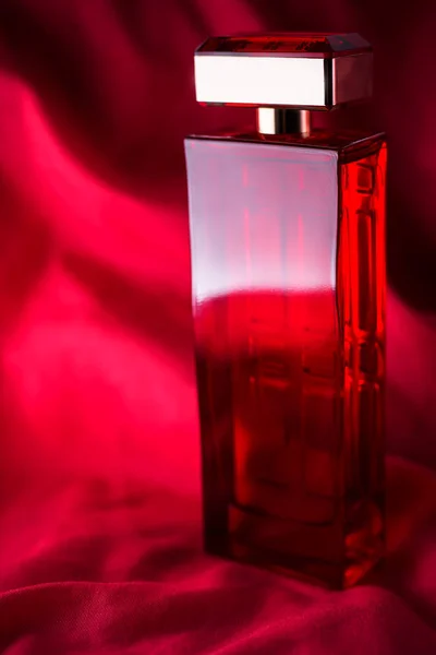 Vrouwelijke parfum op rode achtergrond — Stockfoto