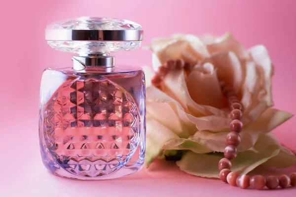 female perfume with pink pearls and flower