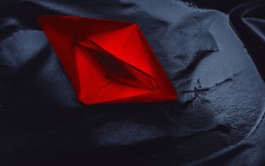 Siyah arka planda kırmızı kağıt tekne