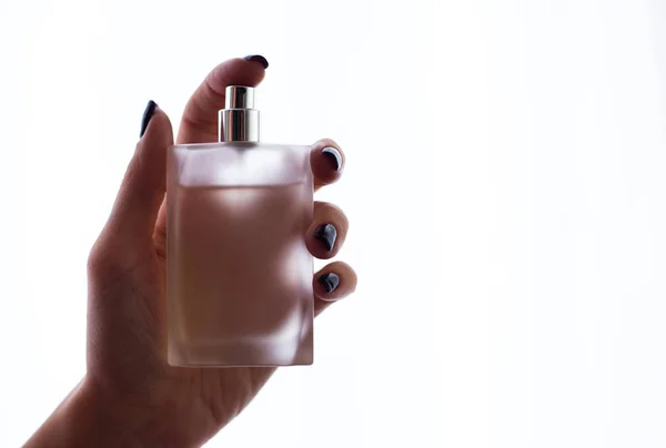 女性的手将香水放在白色的背景上 — 图库照片