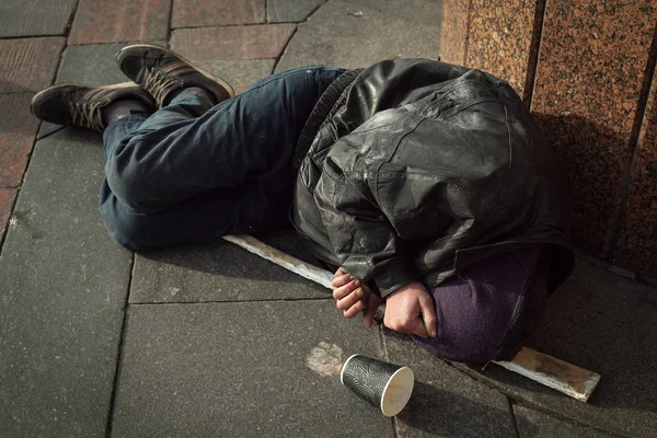 Hombre sin hogar y hambriento durmiendo en la calle — Foto de Stock