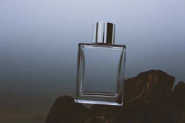 Láhev parfému na modrém pozadí — Stock fotografie