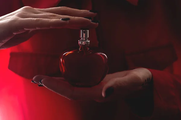 red perfume in female hands