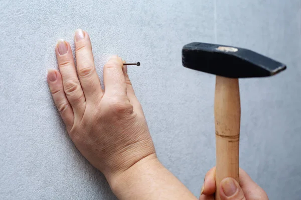 architect hammering nail in wall