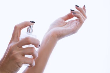 perfume in women's hands over white 