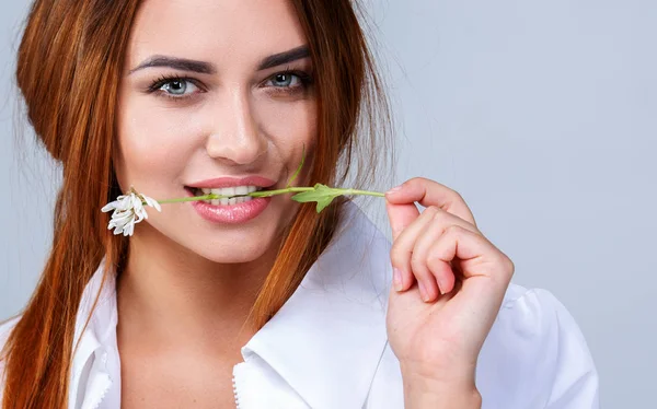 Flor delicada na boca de uma menina bonita — Fotografia de Stock