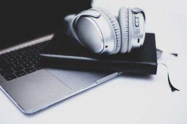Kulaklıklar, dizüstü bilgisayarın üzerinde, masa başında. Müzik konsepti. 