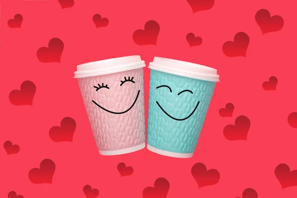 Two coffee cup with smiling face of man and woman together on pink background. Concept of happy Valentines day.