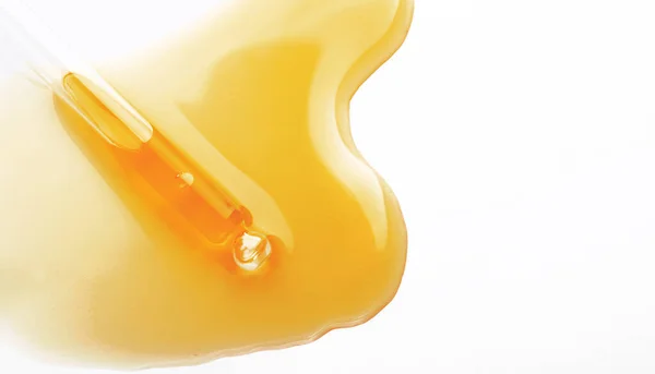 Sarı serum veya beyaz zemin üzerinde izole edilmiş zeytin yağı dokusu, şeffaf baloncuk jeli kozmetik örneği. Altın sıvı asit krem numunesi veya bal damlası