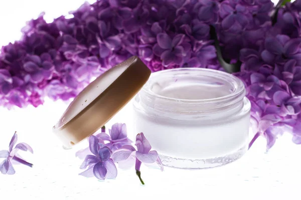 Face and body skin care. cosmetic cream in white tubes with sprigs of lilac flowers. Spa treatments for home care. Home rejuvenation and moisturizin
