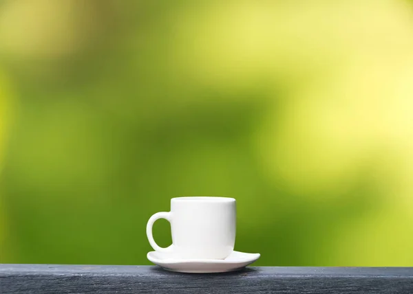 绿色散景背景上的白色咖啡杯 — 图库照片