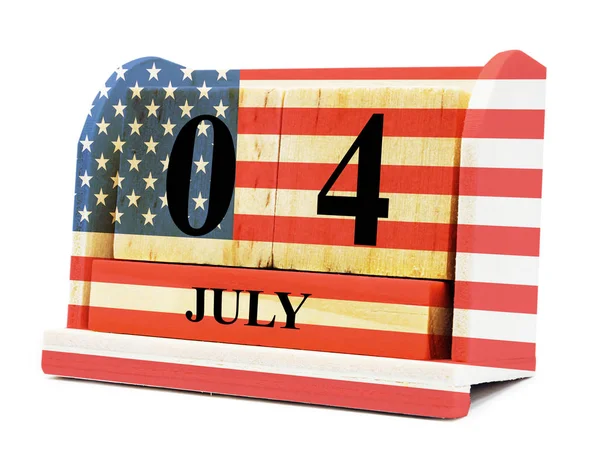 Cube shape calendar for July 04 on wooden surface with USA flag — Stock Photo, Image