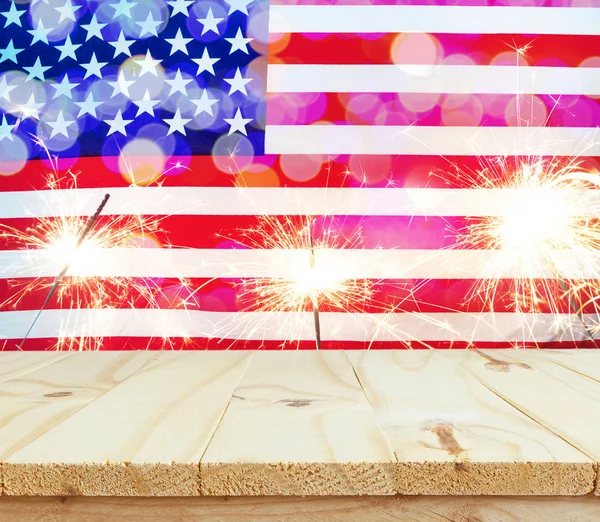 Mesa de madeira na bandeira dos EUA com fundo sparklers — Fotografia de Stock
