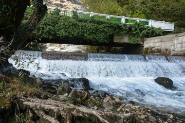 Bir küçük şelale köprünün altından yayılan. 