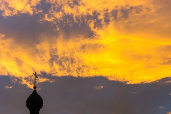 Kyrkan kupoler på bakgrunden av himlen orange-gul. — Stockfoto