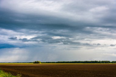 Yağmur bulutları ve sürülmüş alan. 