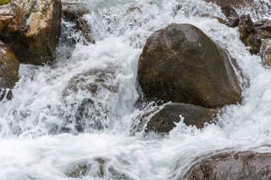 Büyük ıslak kayaların kaynar su akışı. 