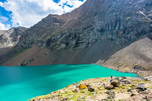 Os turistas na margem de um lago de montanha Ala-Kul, Quirguistão — Fotografia de Stock