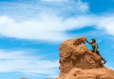 Mavi gökyüzü, Kırgızistan karşı büyük bir kaya üzerinde bir adam duruyor. 
