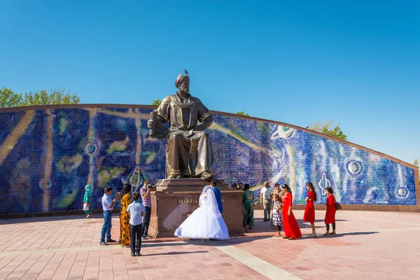 Recién casados en el monumento a Ulugbek el 19 de agosto de 2016 en Samarcanda, Uzbekistán . — Foto de Stock