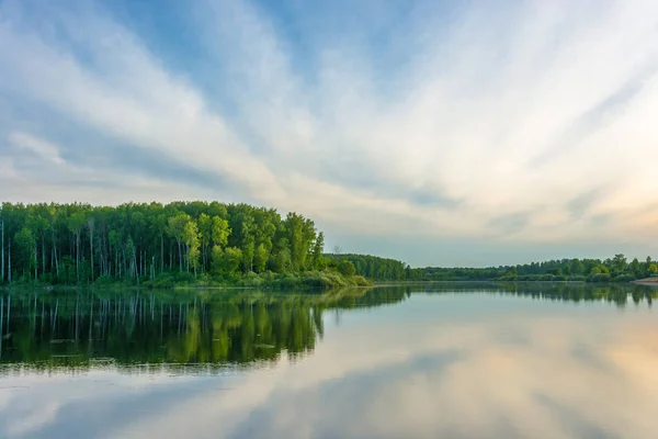 Het gespiegelde oppervlak van de rivier met weerspiegeling van wolken. — Stockfoto