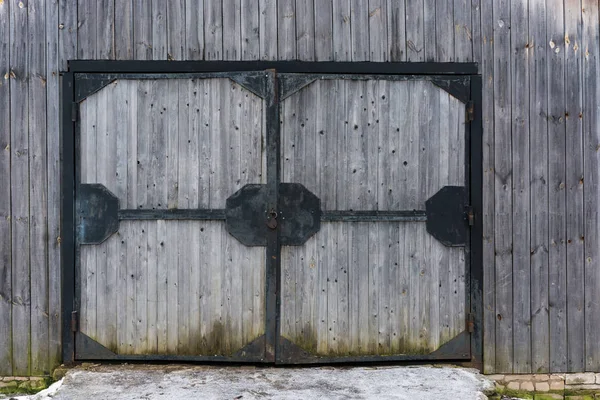 Grote houten poort in een ijzeren frame. — Stockfoto