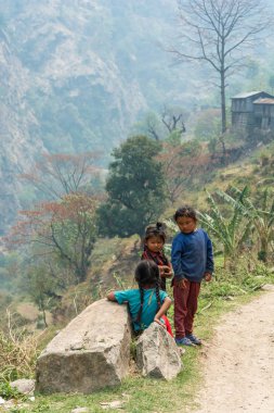 Nepal-Mart 28, 2018: Üç küçük kız dağ yolun kenarında 28 Mart 2018 üzerinde Nepal'de standı.
