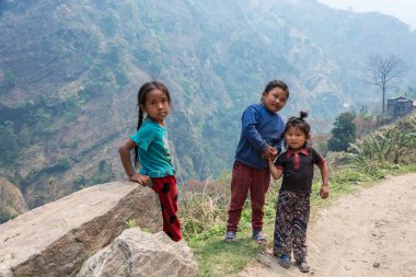 Nepal-Mart 28, 2018: Üç küçük kız dağ yolun kenarında 28 Mart 2018 üzerinde Nepal'de standı. 