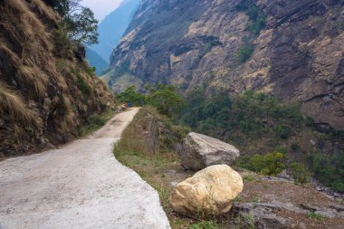 Turistler bir Trek çevresinde Annapurna, Nepal Himalayalar bir dağ yolu üzerinde.