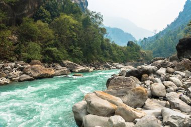 Zor bir bahar günü, Himalayalar, Nepal taş kıyısında nehirde dağ. 