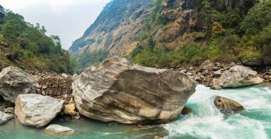 Zor bir bahar günü, Himalayalar, Nepal taş kıyısında nehirde dağ. 