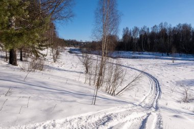 Güneşli bir kış gününde ve mavi gökyüzünde küçük bir nehir manzarası,
