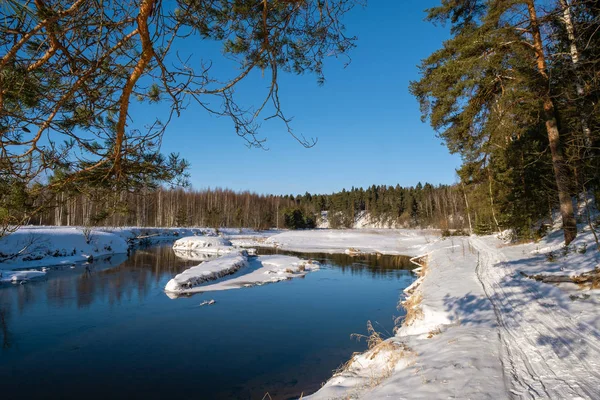 Paisagem com um pequeno rio em um dia ensolarado de inverno e céu azul . — Fotografia de Stock