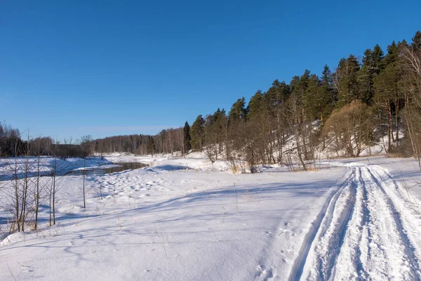Paisagem com um pequeno rio em um dia ensolarado de inverno e céu azul , — Fotografia de Stock