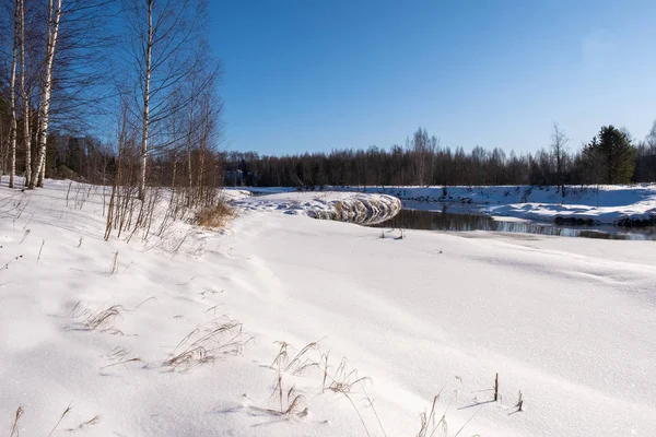 Paisagem com um pequeno rio em um dia ensolarado de inverno e céu azul . — Fotografia de Stock