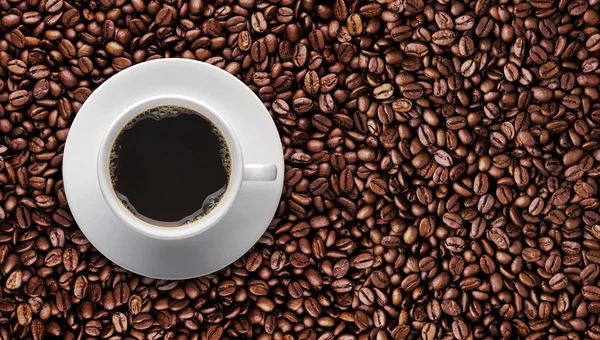 Tazza di caffè su chicco di caffè arrosto con spazio di copia del testo . — Foto Stock