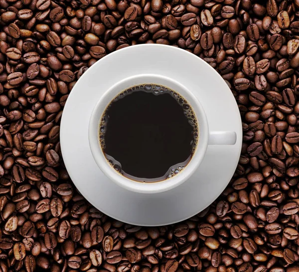 Tazza di caffè caldo su chicchi di caffè arrosto. Vista dall'alto — Foto Stock