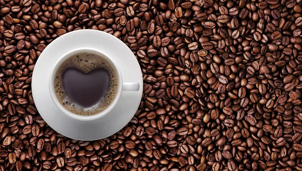 Svart kaffekopp kärlek med hjärta form på kaffebönor — Stockfoto