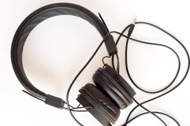 Beyaz arka planda klasik siyah kulaklıklar. Retro tarzı. Minimalist müzik konsepti.