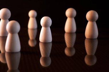 Bir sürü tahta piyon ve siyah arka planda. Sosyal uzaklık