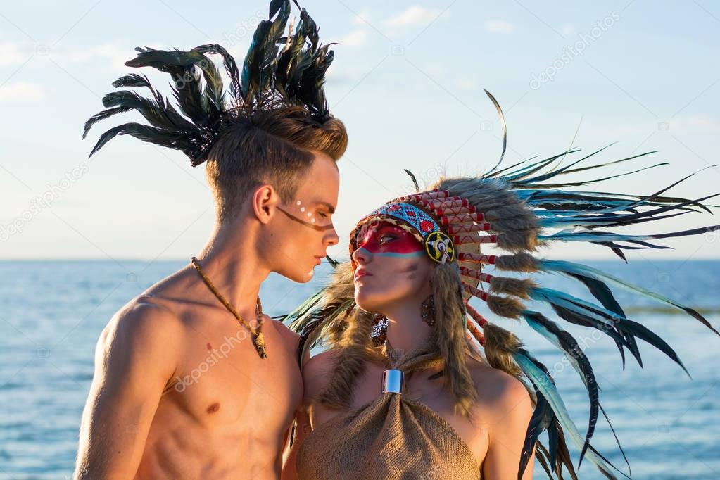 Man with an american indian coloring and feathers on his head em