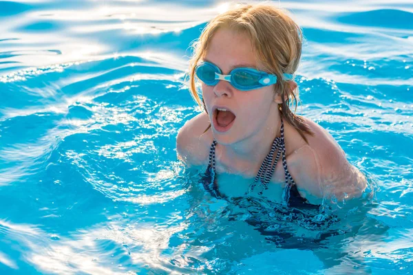 Niña nada en la piscina con gafas para nadar — Foto de Stock