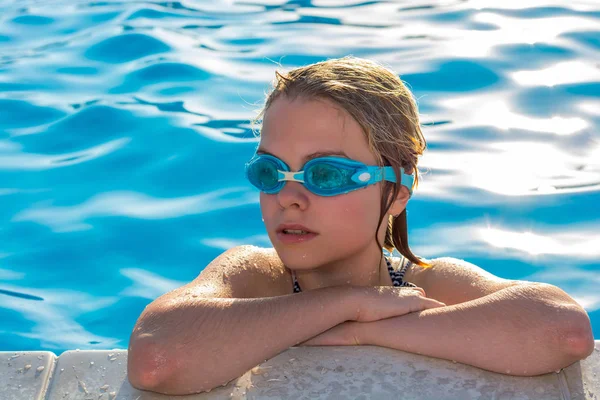 Niña nada en la piscina con gafas para nadar . — Foto de Stock