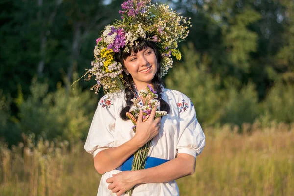 Una joven con una larga camisa bordada blanca y una corona de flores —  Fotos de Stock