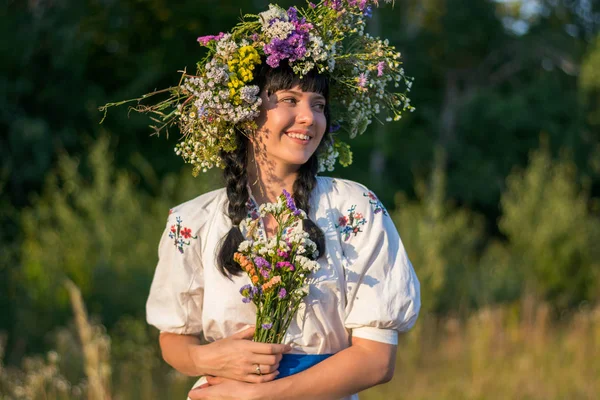 Una joven con una larga camisa bordada blanca y una corona de flores —  Fotos de Stock