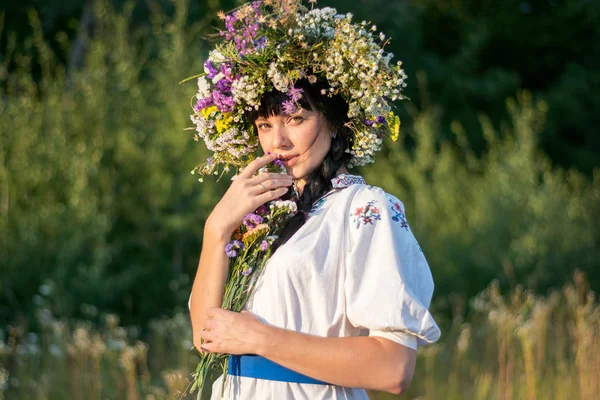 Genç bir kadın uzun beyaz işlemeli tişört ve çelenk 
